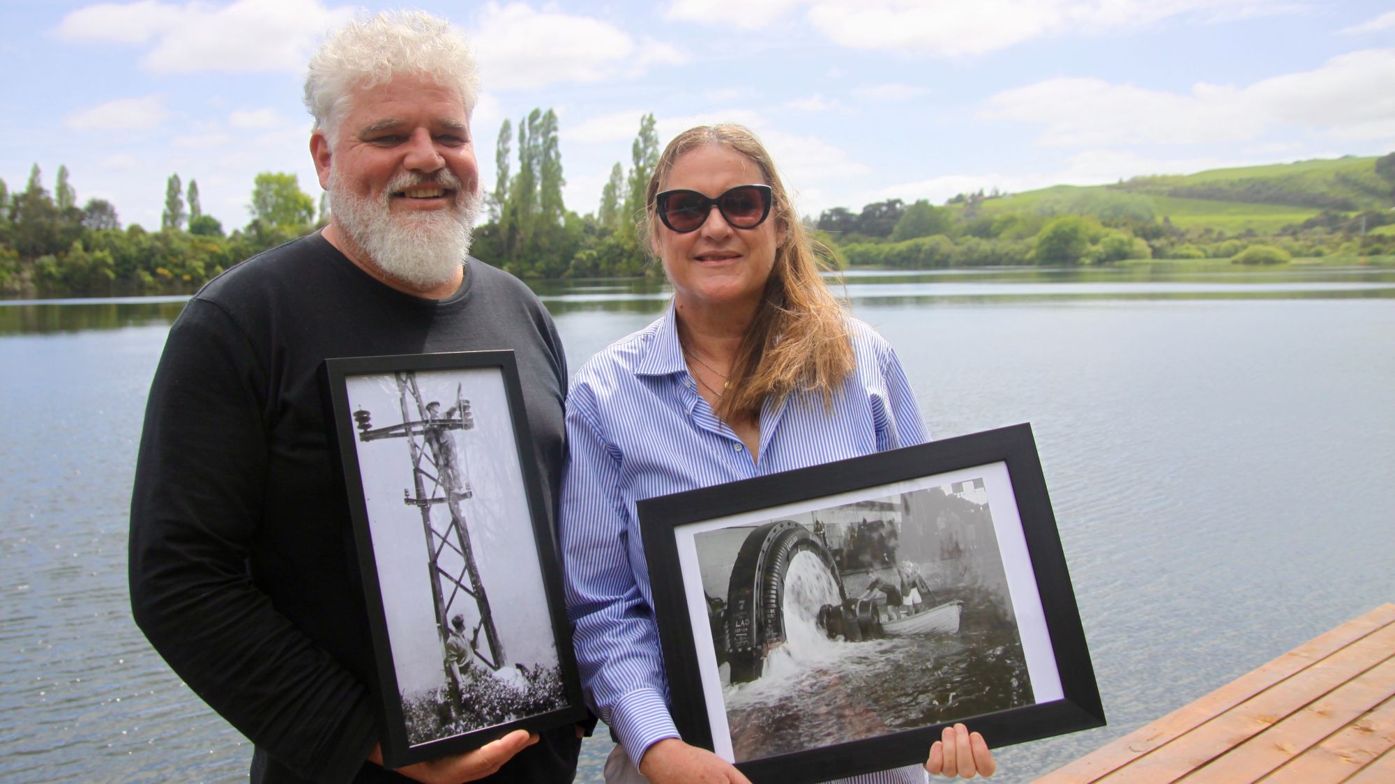 Joe Hall and Larnie Chrystall holding pictures of the Horahora Power Station