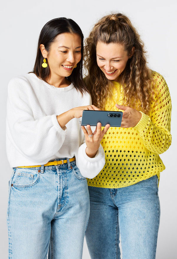 Studio life women looking at phone lo res 600x1080