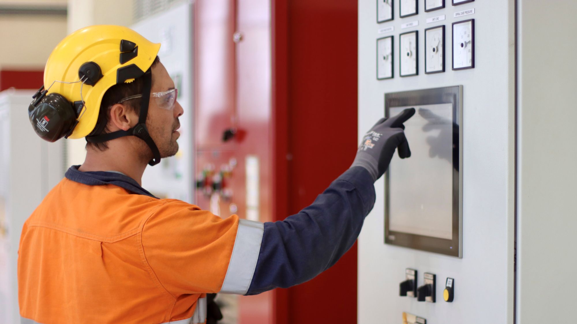 Taz in PPE selecting items on a touch screen at a control panel