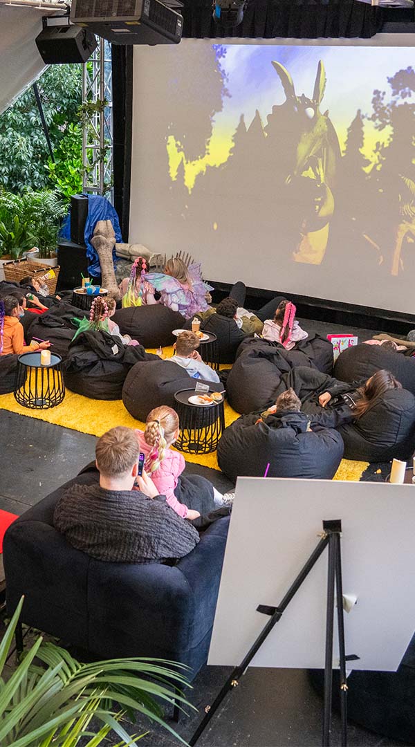Children and friends watching a movie in outdoor garden theatre